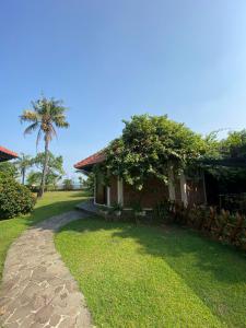 a house with a palm tree and a path at Jepara Marina Beach Bungalows in Jepara