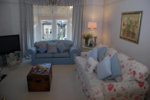 uma sala de estar com um sofá e uma mesa em Springdale Guest House em Harrogate