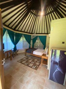 Jepara Marina Beach Bungalows في جيبارا: غرفة بسرير في خيمة
