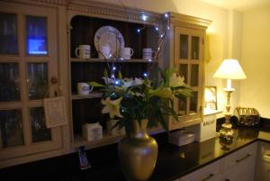 a vase with flowers on a counter in a kitchen at Springdale Guest House in Harrogate