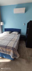 um quarto com uma cama com uma parede azul em Northern C y p r u s Trikomo, Iskele, Long Beach, Caesar Resort apartment Commodus -SMART TV em Trikomo