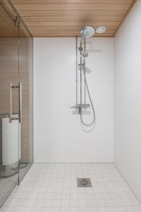 a bathroom with a shower in a white wall at "Station" - Modern 1BR with Sauna next to Railway Station, Hosted by 2ndhomes in Tampere +22 photos