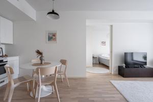 a kitchen and living room with a table and chairs at 2ndhomes Tampere Brand New "Station" Apartment with Sauna in Tampere