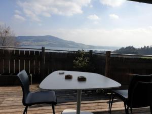 une table et des chaises blanches sur une terrasse avec vue dans l'établissement Apartment im Salzburger Seenland, à Seeham