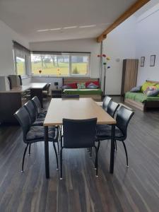 - une chambre avec une table, des chaises et un canapé dans l'établissement Apartment im Salzburger Seenland, à Seeham