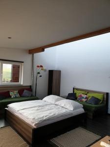 a bedroom with a bed and a couch at Apartment im Salzburger Seenland in Seeham