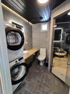 a small bathroom with a washer and dryer in it at Pikkuhukka in Syöte +31 photos