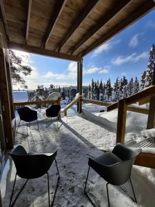 een patio met stoelen en uitzicht op de met sneeuw bedekte bomen bij Pikkuhukka in Syöte