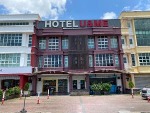 a hotel ume with a sign on the front of it at Hotel U and Me in Kulai