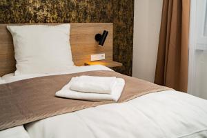 Una cama con una toalla encima. en Gästehaus Würzburg 24h, en Estenfeld 201 fotos más
