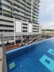 une piscine en face d'un grand bâtiment dans l'établissement Cozy Home Cinema @ Mount Austin JB 5 Pax, à Johor Bahru
