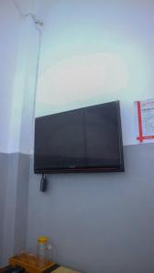 a flat screen tv hanging on a wall at 360 Homestay Padang in Kampungdurian