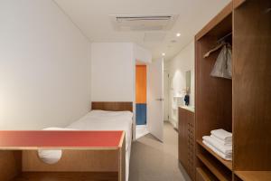 ソウルにあるMangrove Dongdaemunのベッド1台とバスルームが備わる小さな客室です。