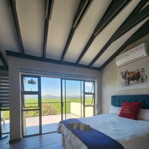a bedroom with a large bed and a large window at Kosmos, Hartbeespoort in Hartbeespoort