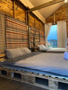 2 camas en una habitación con paredes de madera en Sun Homestay Mang Den, en Kon Von Kla