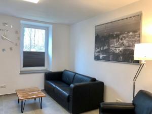a living room with a black couch and a table at Erdgeschoss-Appartement mit Seeterasse in Ahrensbök