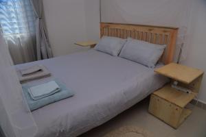 a bedroom with a large bed with a wooden headboard at Lion King Mufasa in Mukono
