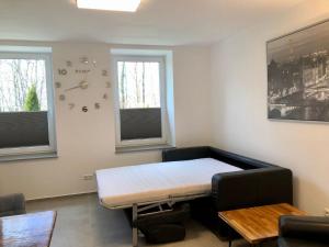 a room with a bed and a table and two windows at Erdgeschoss-Appartement mit Seeterasse in Ahrensbök