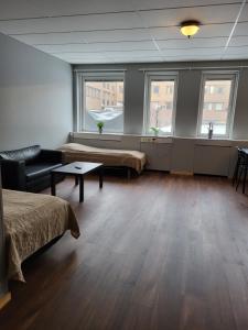 Cette grande chambre comprend deux lits et une table. dans l'établissement Apartments Centralstation, à Uppsala