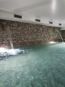 uma grande piscina de água com duas fontes de água em Quinta de Travassinhos- Douro Valley em Santa Marta de Penaguião
