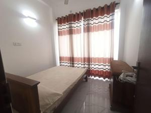 a small room with a bed and a window at 3 bedroom fully furnished apartment - Vel residencies in Colombo