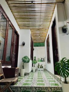 a porch with plants and a wooden ceiling at N'T Homestay in Mui Ne