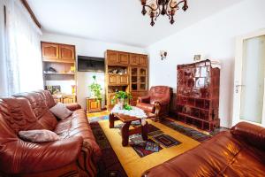 a living room with leather couches and a table at Grandma's apartment in Velika