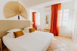 ニースにあるPalm Boutique Hôtel Niceのベッドルーム1室(上に傘付きの大きな白いベッド1台付)
