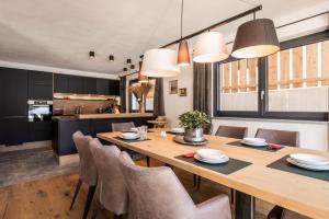 cocina y comedor con mesa de madera y sillas en Wilderer Chalets en Leutasch