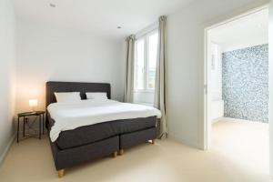 a bedroom with a bed and a large window at Lichtrijk appartement op toplocatie in Gent in Ghent