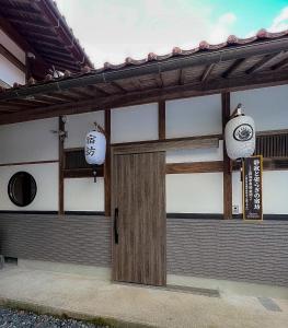 un edificio con una puerta y una señal en él en 宿坊-地蔵院 en Kurayoshi