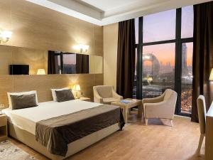 NOBEL Hotel في باكو: غرفة فندقية بسرير ونافذة كبيرة