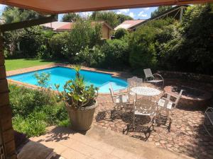 a patio with a table and chairs next to a pool at Schilbach House in Parys