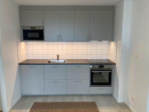 a kitchen with white cabinets and a sink at Blå Dörren in Höör