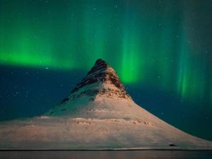 a mountain with the aurora in the sky at Bjarg Apartments in Grundarfjordur