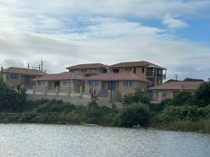 eine Reihe von Häusern neben einem Wasserkörper in der Unterkunft Coastal Beach Resort in Umkomaas