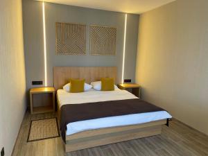 a bedroom with a large bed with yellow pillows at Hotel Complex Ukraine in Lutsk