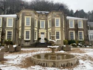 um grande edifício com uma fonte em frente em New House Country Hotel em Cardiff