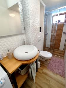 a white bathroom with a sink and a toilet at Grandma's apartment in Velika