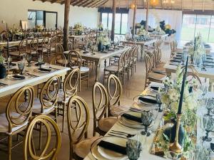 a banquet hall with long tables and chairs at Coastal Beach Resort in Umkomaas