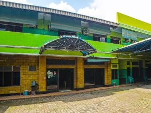 een gebouw met een groen en geel bij SPOT ON 92340 Lida Hotel in Medan