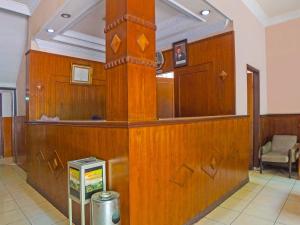 een lobby met een houten muur en een ticketbalie bij SPOT ON 92340 Lida Hotel in Medan