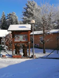 a kiosk in the snow next to a building at Spreewaldhäuser Golinski mit Kamin am Neuendorfer See in Alt Schadow