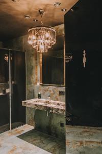 een badkamer met een wastafel en een kroonluchter bij LA vie Hotel Landshut in Landshut
