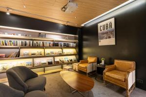 a waiting room with chairs and a table and books at Hub Hotel in Zhongli