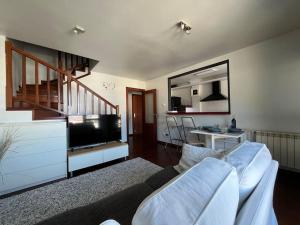 sala de estar con sofá y TV en Duplex Bahía de Santoña en Santoña