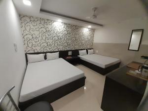 a small room with two beds and a table at Hotel Shree in Hisār