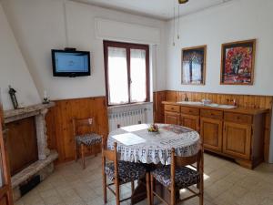 una cucina con tavolo, sedie e TV di CASA CAMELIA a Capannori