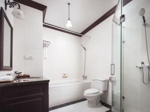 a bathroom with a tub and a toilet and a sink at Chateau d'Angkor La Residence in Siem Reap