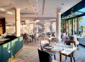 un restaurant avec des tables, des chaises et des fenêtres dans l'établissement Villa Toscane, à Montreux